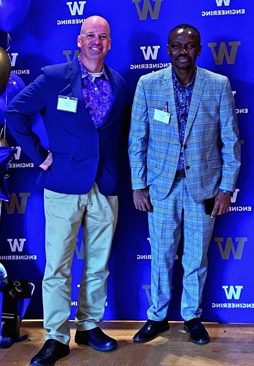 A 澳博体育app下载 Leadership Diversity Scholar stands with a 澳博体育app下载 Ambassador in front of a Univeristy of Washington Engineering step and repeat.